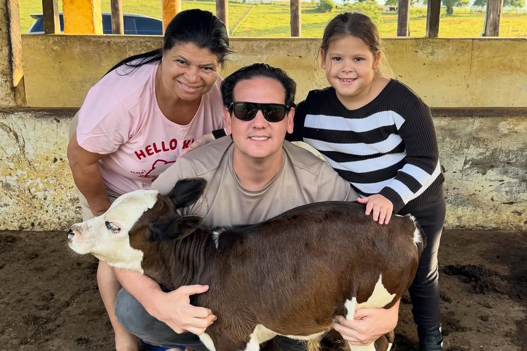 André Amaral Filho no curral, com uma família e um bezerro